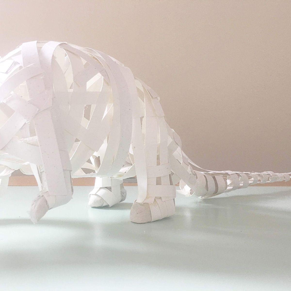 a frame of a pangolin made out of paper strips