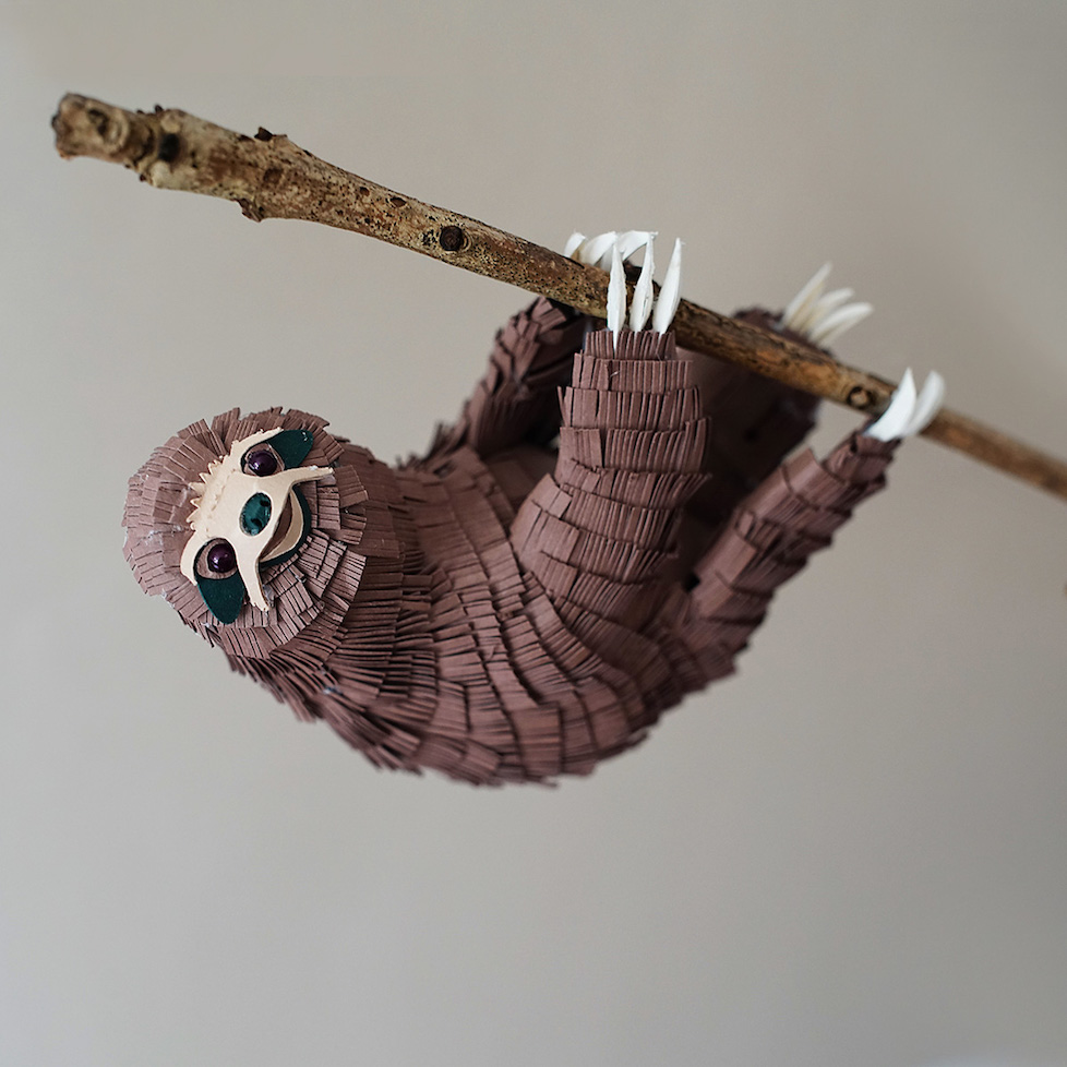 paper sloth sculpture hanging on a branch